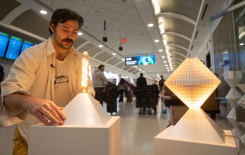 Samuel Thurman installs digitally designed and fabricated lamps in the Atlanta airport. Photo by Rob Felt